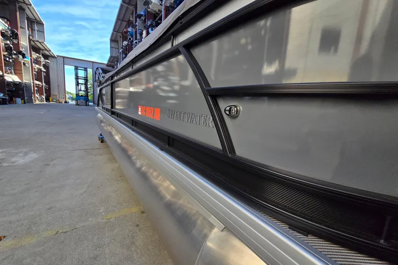 Slide: The Image of 2024 Godfrey Sweetwater 2486 SB pontoon boat in a marina storage area. - 4