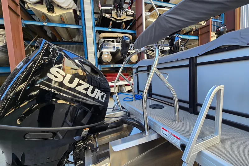 Slide: The Image of 2024 Godfrey Sweetwater 2486 SB with Suzuki four-stroke engine in storage facility. - 10