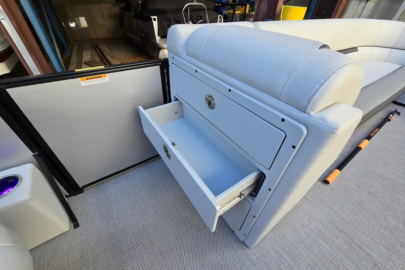Slide: The Image of 2024 Godfrey Sweetwater 2486 SB boat interior with open storage drawer and seating. - 27