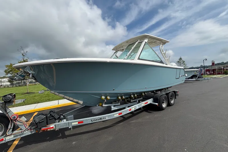 The Image of The 2027 Sailfish 276 DC is on a trailer. It features a blue hull and a white top. - 0