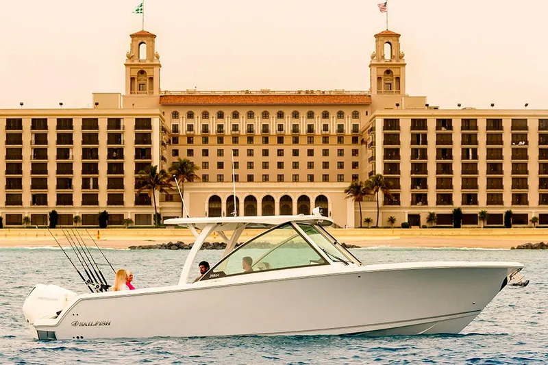Slide: The Image of Manufacturer Provided Image: 2026 Sailfish 316 DC boat cruising near a grand waterfront hotel. - 1