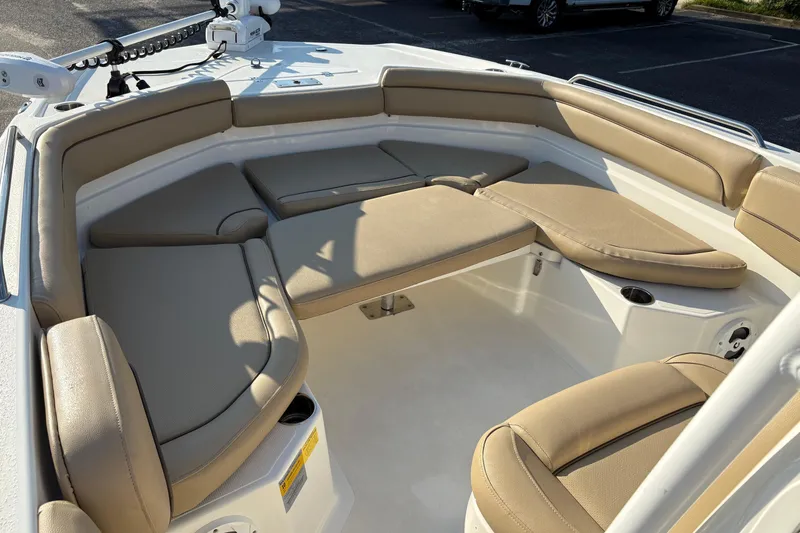 Slide: The Image of 2019 NauticStar 231 Hybrid boat interior with tan cushioned seating and cup holders. - 25