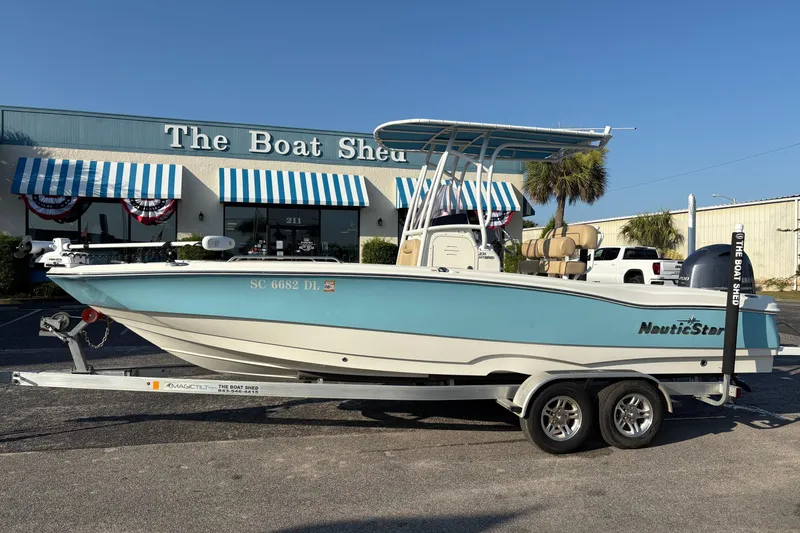 The Image of 2019 NauticStar 231 Hybrid boat on trailer outside The Boat Shed dealership. - 0