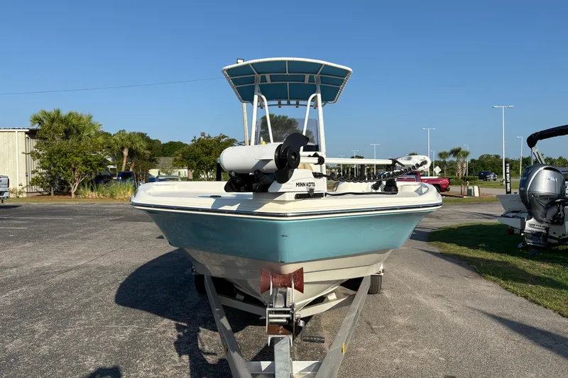 Slide: The Image of 2019 NauticStar 231 Hybrid boat on trailer, parked outdoors under clear blue sky. - 5