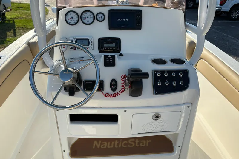 Slide: The Image of 2019 NauticStar 231 Hybrid boat dashboard with steering wheel and navigation controls. - 14