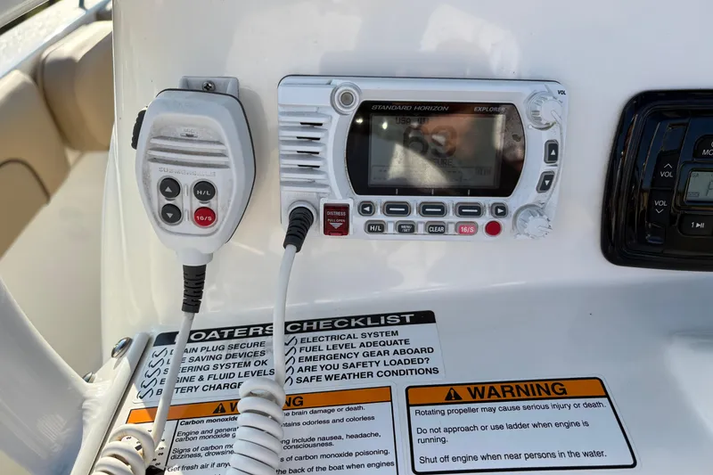 Slide: The Image of Control panel of a 2019 NauticStar 231 Hybrid boat with radio and safety checklist. - 17