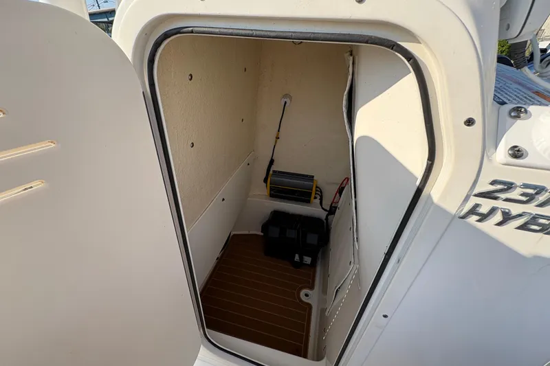 Slide: The Image of Storage compartment of a 2019 NauticStar 231 Hybrid boat, featuring interior equipment. - 21