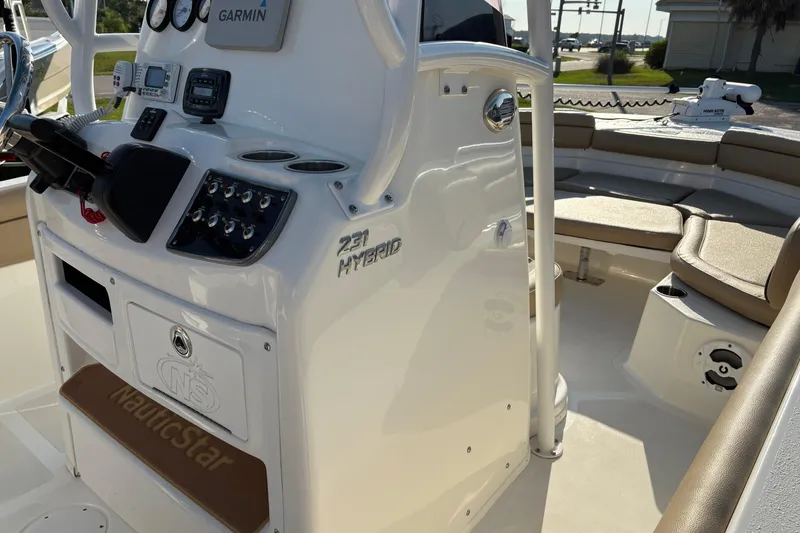 Slide: The Image of 2019 NauticStar 231 Hybrid boat interior with Garmin electronics and seating area. - 19
