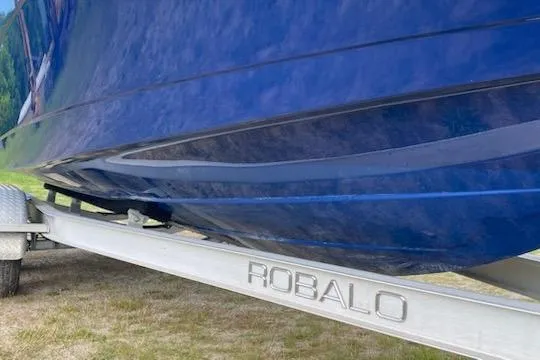 Slide: The Image of 2017 Robalo R222 Center Console boat on trailer, blue hull visible. - 3