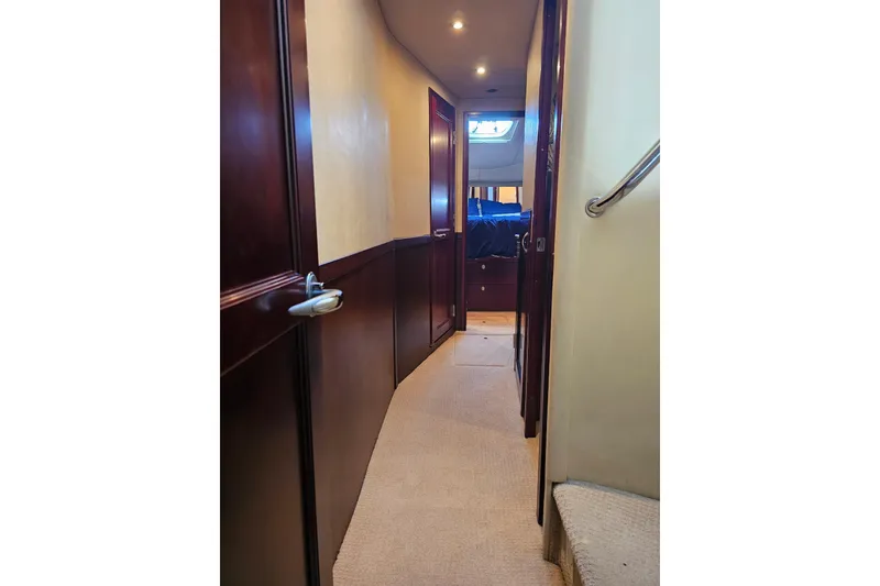 Slide: The Image of Hallway inside 2006 Sea Ray 580 Sedan Bridge yacht, featuring wooden doors and carpeted flooring. - 21