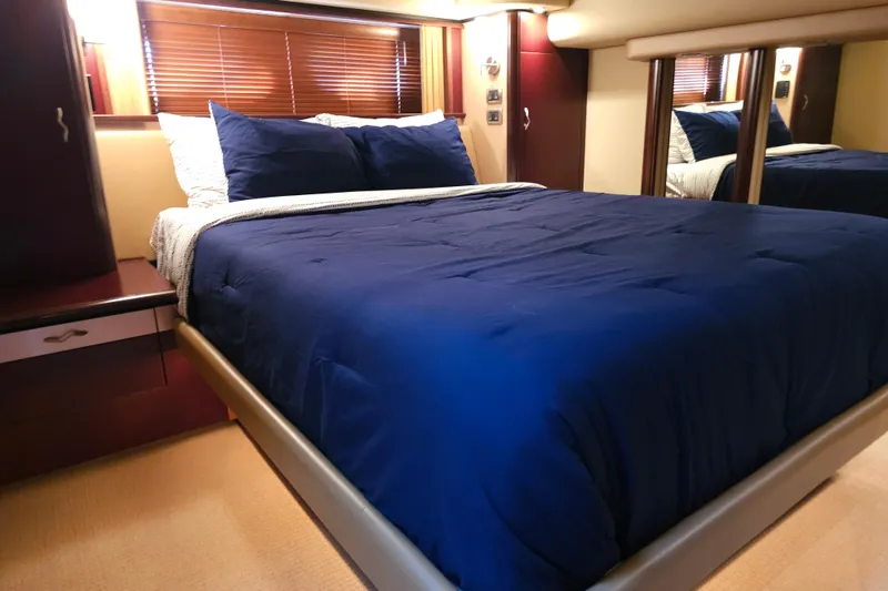 Slide: The Image of Luxurious bedroom interior of 2006 Sea Ray 580 Sedan Bridge yacht with blue bedding. - 29