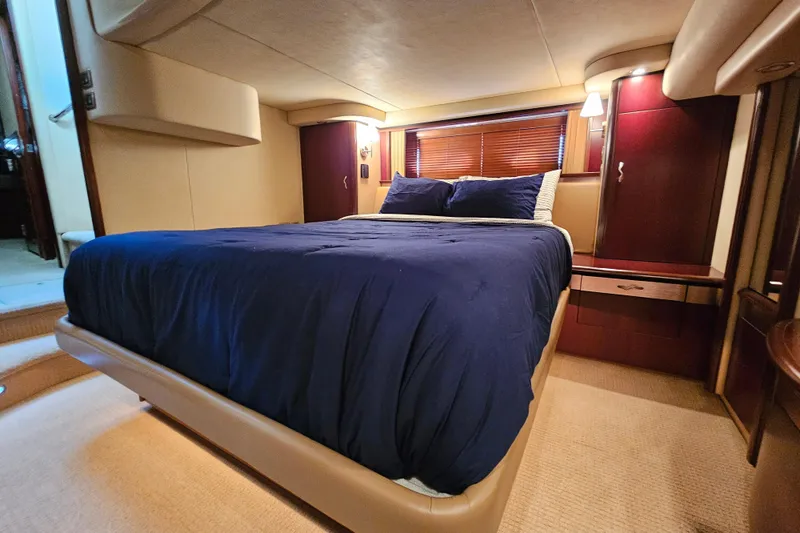Slide: The Image of Luxurious bedroom interior of 2006 Sea Ray 580 Sedan Bridge yacht with blue bedding. - 31