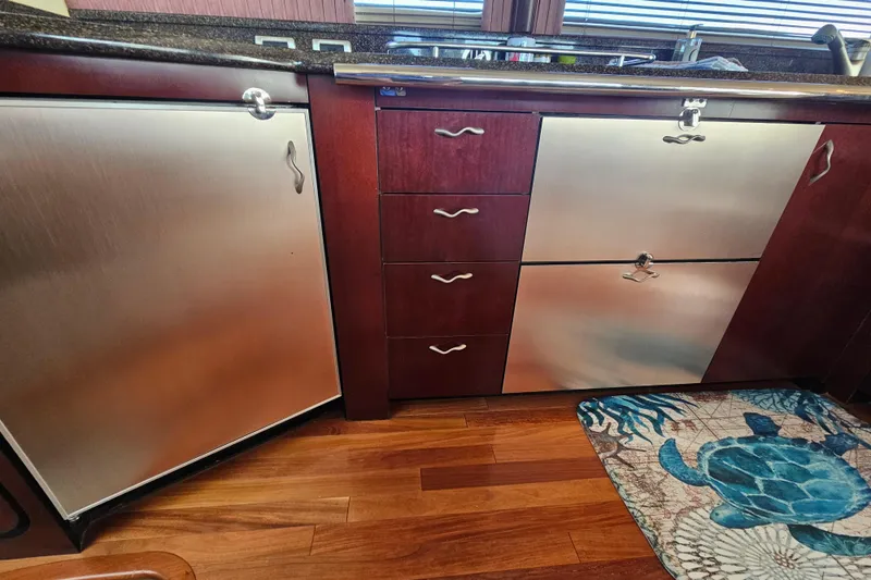 Slide: The Image of Luxury yacht kitchen with stainless steel appliances, wooden cabinets, and turtle-themed rug. Sea Ray 580 Sedan Bridge 2006. - 22
