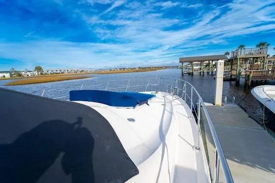 Slide: The Image of 2006 Sea Ray 580 Sedan Bridge yacht docked by a scenic waterfront. - 15