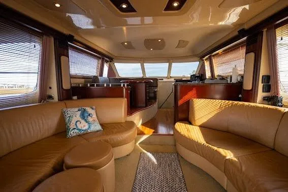Slide: The Image of Luxurious interior of 2006 Sea Ray 580 Sedan Bridge yacht with elegant seating and panoramic windows. - 25