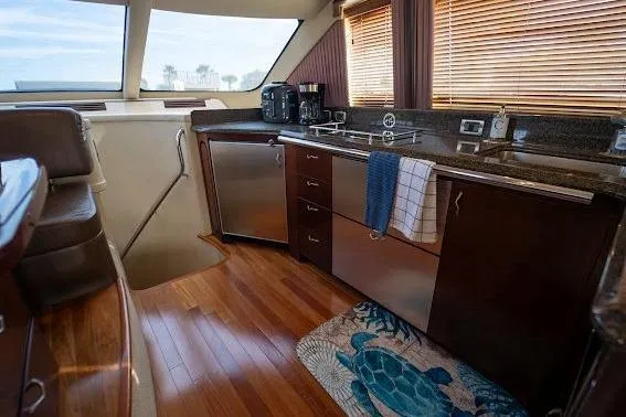 Slide: The Image of Luxurious 2006 Sea Ray 580 Sedan Bridge yacht kitchen with modern appliances and wooden flooring. - 38