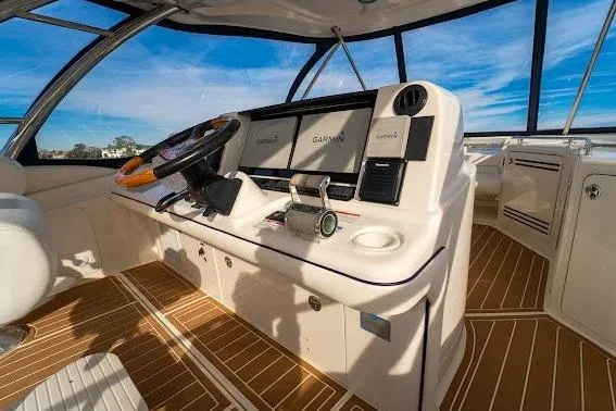 Slide: The Image of 2006 Sea Ray 580 Sedan Bridge helm with modern navigation equipment and wooden flooring. - 12