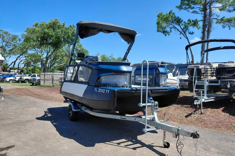 The Image of 2024 Sea-Doo Switch Cruise 18 on trailer, parked outdoors under clear blue sky. - 1