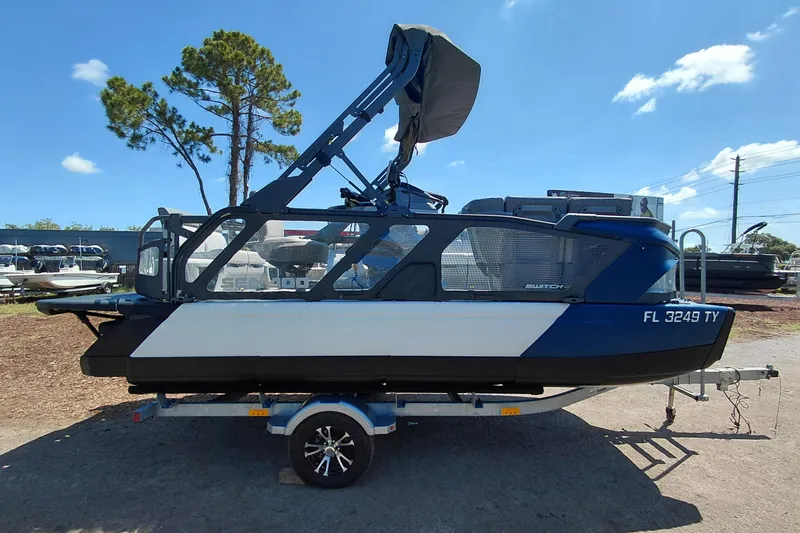 Slide: The Image of 2024 Sea-Doo Switch Cruise 18 pontoon boat on trailer, side view, outdoors. - 7
