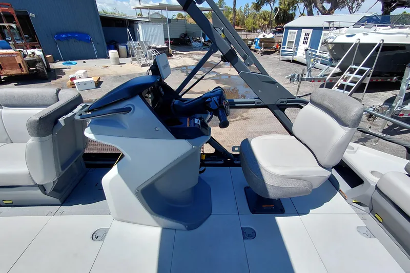 Slide: The Image of 2024 Sea-Doo Switch Cruise 18 interior with steering console and seating in a marina setting. - 29