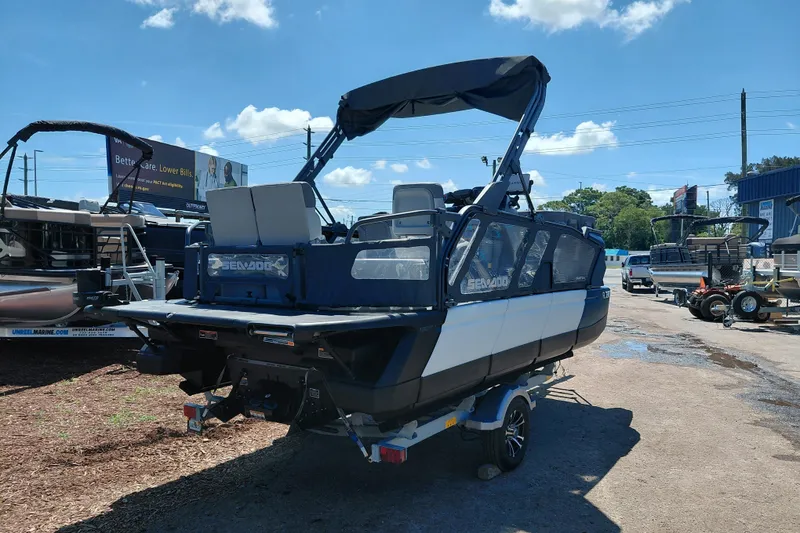 Slide: The Image of 2024 Sea-Doo Switch Cruise 18 pontoon boat on trailer, outdoor dealership display. - 6