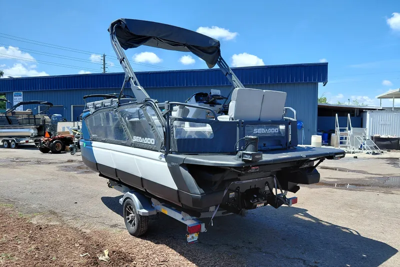Slide: The Image of 2024 Sea-Doo Switch Cruise 18 pontoon boat parked outdoors on a sunny day. - 4