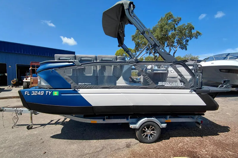 Slide: The Image of 2024 Sea-Doo Switch Cruise 18 pontoon boat on trailer, blue and white design. - 3