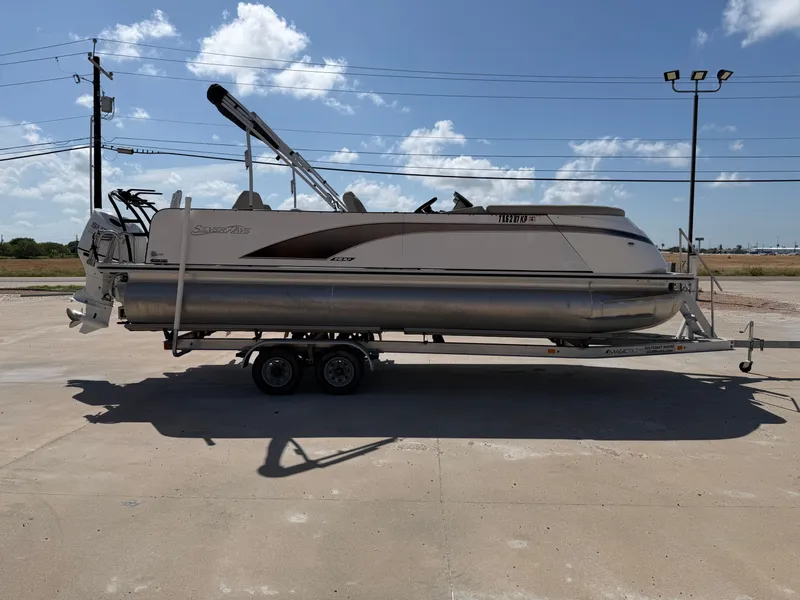 Slide: The Image of A 2022 SilverWave 2410 RLP SW3 pontoon boat on a trailer in a parking lot. - 7