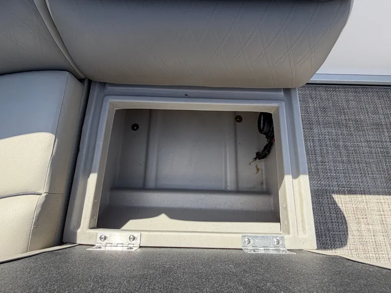 Slide: The Image of An open storage compartment on a boat with gray upholstery and carpeted flooring. - 26
