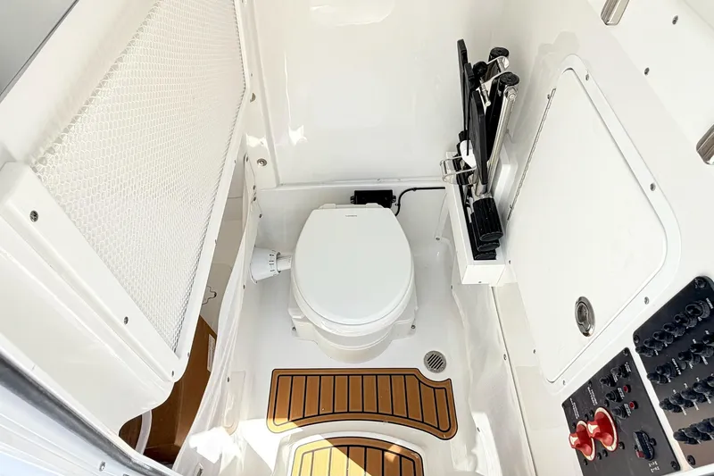 Slide: The Image of Interior of 2027 Sea Hunt Ultra 275 SE boat, featuring a compact marine toilet. - 17