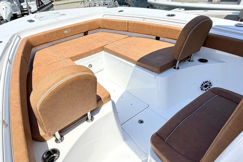 Slide: The Image of 2027 Sea Hunt Ultra 275 SE boat interior with brown cushioned seating. - 23