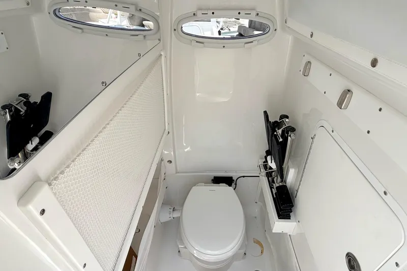 Slide: The Image of Interior of 2027 Sea Hunt Ultra 275 SE boat, featuring a compact marine toilet. - 18