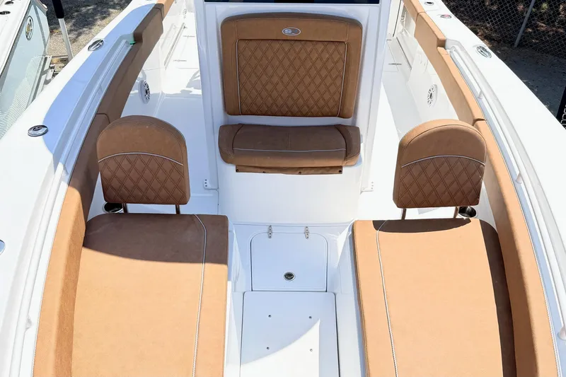Slide: The Image of 2027 Sea Hunt Ultra 275 SE boat interior with tan cushioned seating and white deck. - 25