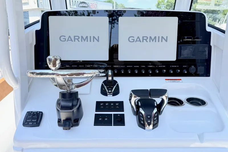 Slide: The Image of Control panel of 2027 Sea Hunt Ultra 275 SE with dual Garmin displays and steering wheel. - 11