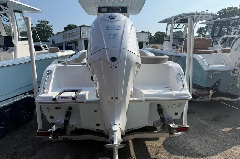 Slide: The Image of 2027 Sea Hunt Ultra 245 SE boat with powerful outboard motor, displayed at a dealership. - 2