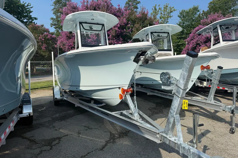 Slide: The Image of 2027 Sea Hunt Ultra 245 SE boats on trailers, surrounded by blooming trees. - 1