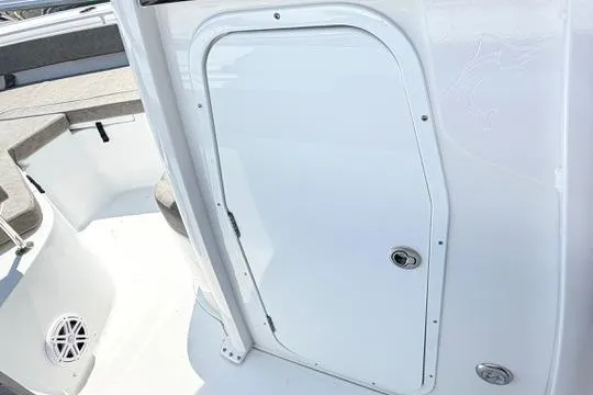 Slide: The Image of 2027 Sea Hunt Ultra 245 SE boat interior with storage compartment door. - 22