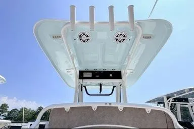 Slide: The Image of 2027 Sea Hunt Ultra 245 SE boat with T-top and rod holders under clear sky. - 10