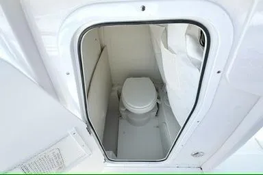Slide: The Image of 2027 Sea Hunt Ultra 245 SE boat interior with compact marine toilet. - 4