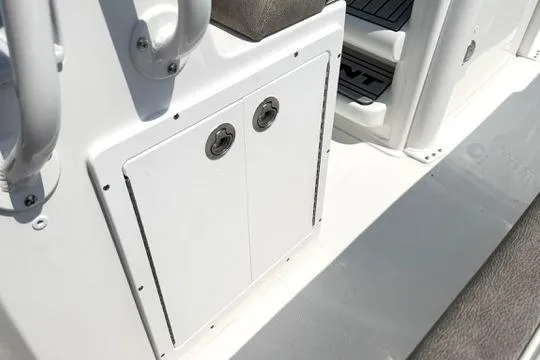 Slide: The Image of 2027 Sea Hunt Ultra 245 SE boat storage compartment with sleek white finish and secure latches. - 18