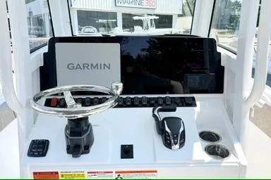 Slide: The Image of 2027 Sea Hunt Ultra 245 SE boat dashboard with Garmin navigation system and steering wheel. - 13