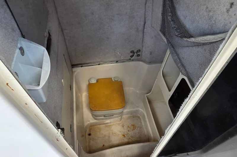 Slide: The Image of Interior of a 1994 Grady-White Chase 263 boat, featuring a compact marine toilet. - 5