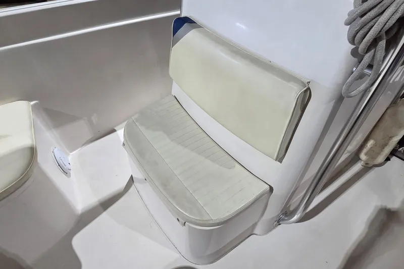 Slide: The Image of 1994 Grady-White Chase 263 boat seat with white cushioned backrest and rope detail. - 15