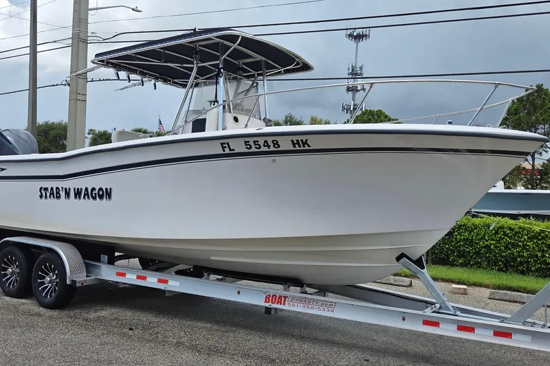 Slide: The Image of 1994 Grady-White Chase 263 boat on trailer, named "Stab'n Wagon," parked outdoors. - 3