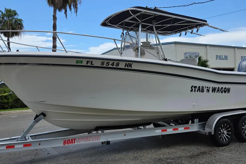 Slide: The Image of 1994 Grady-White Chase 263 boat on trailer, labeled "Stab'n Wagon," parked outdoors. - 2