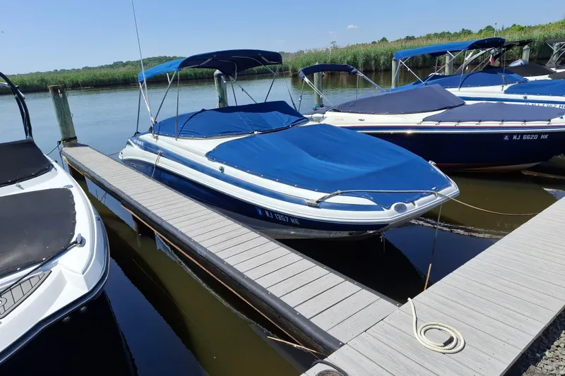 Slide: The Image of 2013 Crownline Eclipse E6 boat docked with blue cover and canopy. - 1