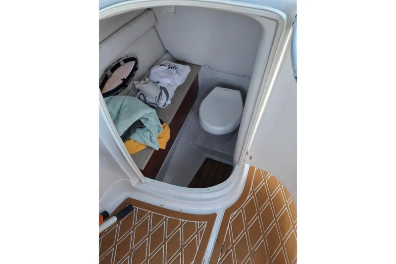 Slide: The Image of 2013 Crownline Eclipse E6 boat interior with compact toilet and storage area. - 11
