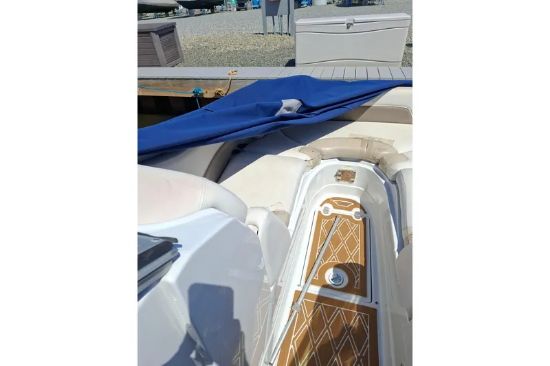 Slide: The Image of 2013 Crownline Eclipse E6 boat interior with blue cover and cushioned seating. - 8