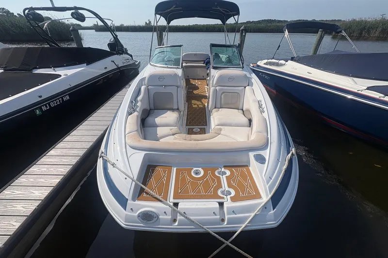 Slide: The Image of 2013 Crownline Eclipse E6 boat docked, featuring spacious seating and elegant design. - 2