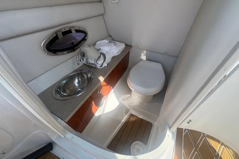Slide: The Image of 2013 Crownline Eclipse E6 boat bathroom with sink, toilet, and porthole window. - 8